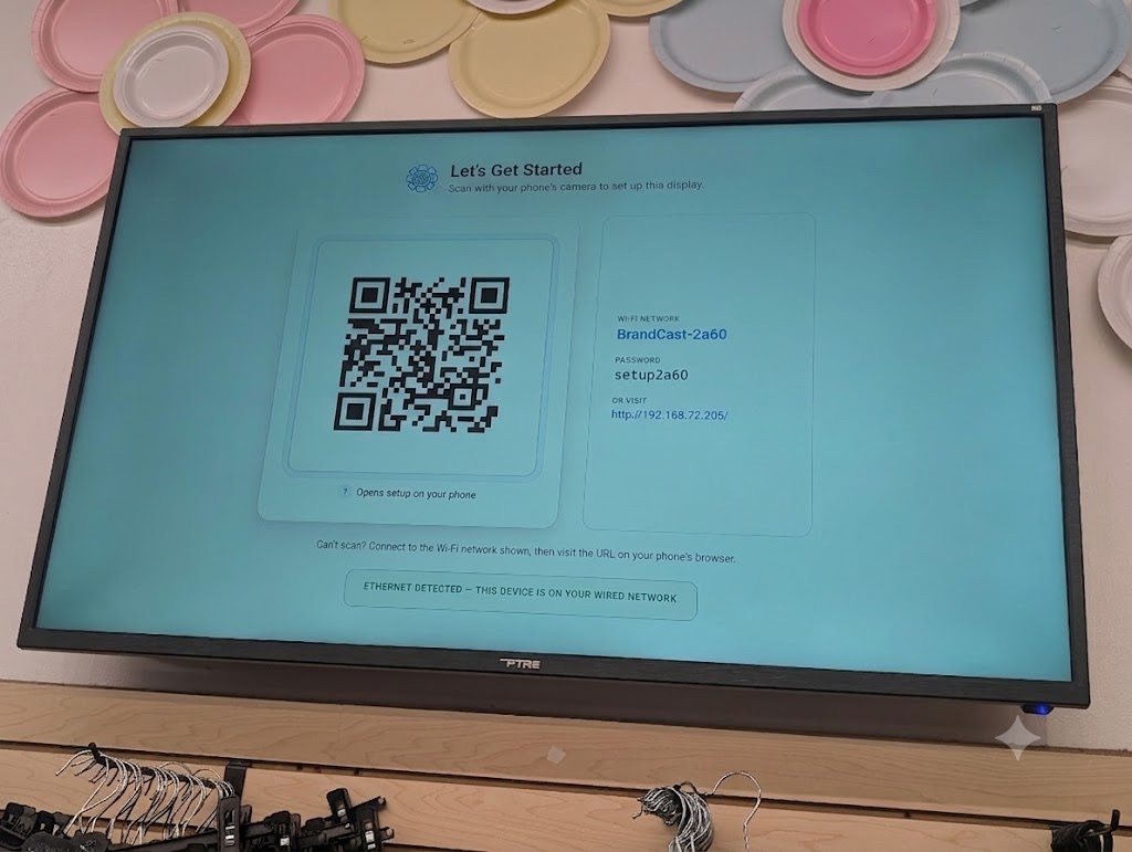 A new BrandCast display showing its first-boot setup screen with a QR code and Wi-Fi details