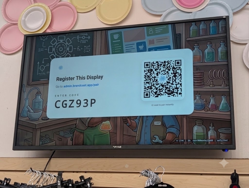 A BrandCast display showing a six-character pairing code and a QR code to register it