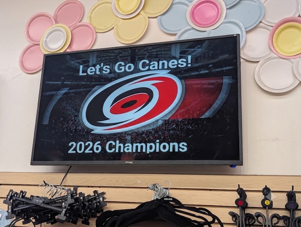 A BrandCast display on the store wall running a Carolina Hurricanes 2026 champions graphic
